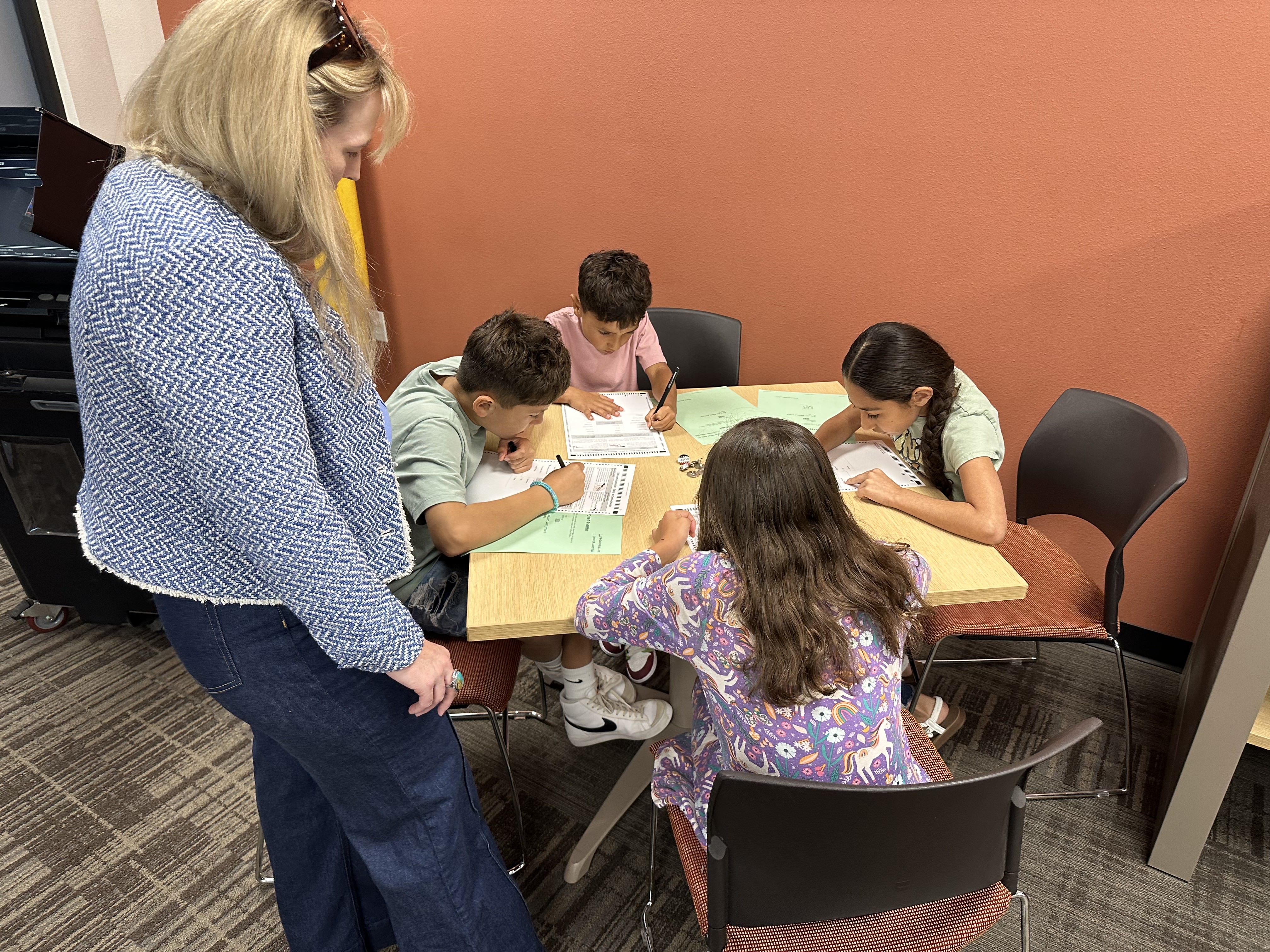 4 kids filling out practice ballots
