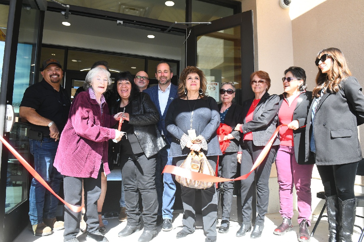 Community members applauding during the ribbon‑cutting ceremony inside the new center.
