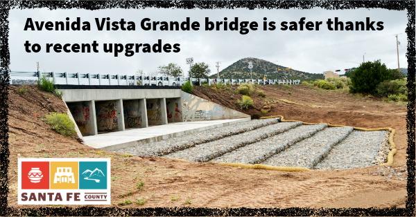 Avenida Vista Grande road goes over a box culvert bridge with recently completed upgrades to the drainage system and railings. The new drainage area includes a concrete apron and gabion baskets.